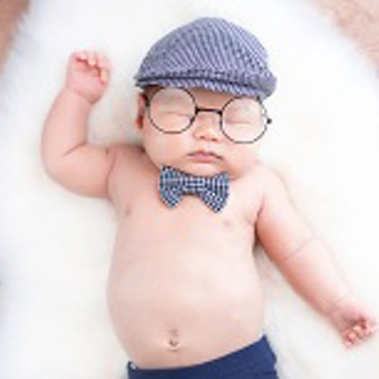 תינוק ישן על שטיח עם משקפי ראיה